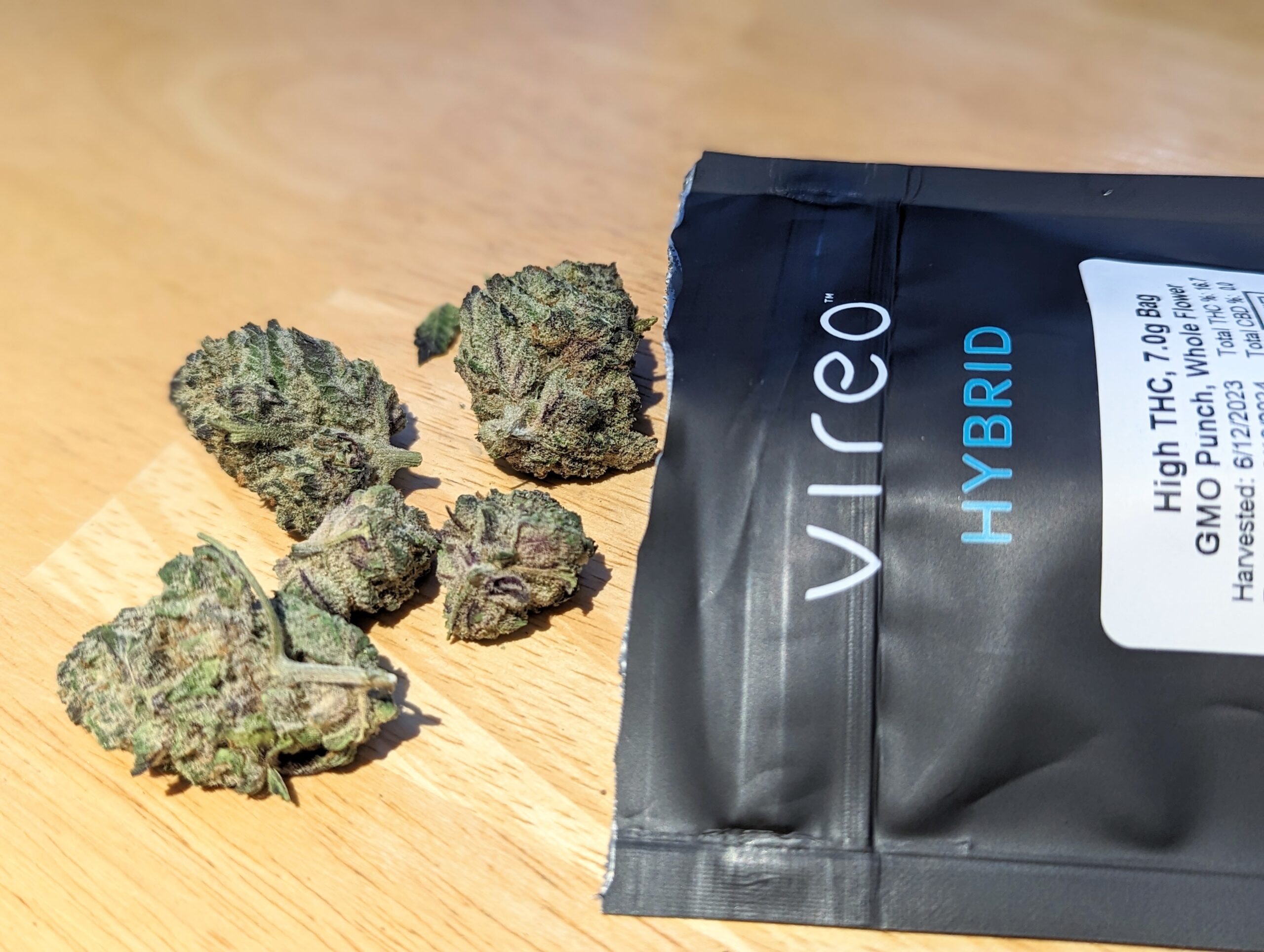 An image of cannabis falling out of a medical dispensary bag on a table.