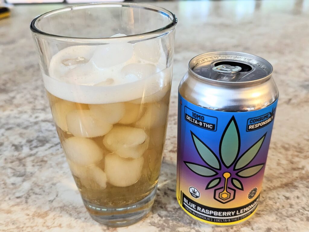 A picture of a can of weed-infused lemonade next to a tall clear glass filled with ice and lemonade.
